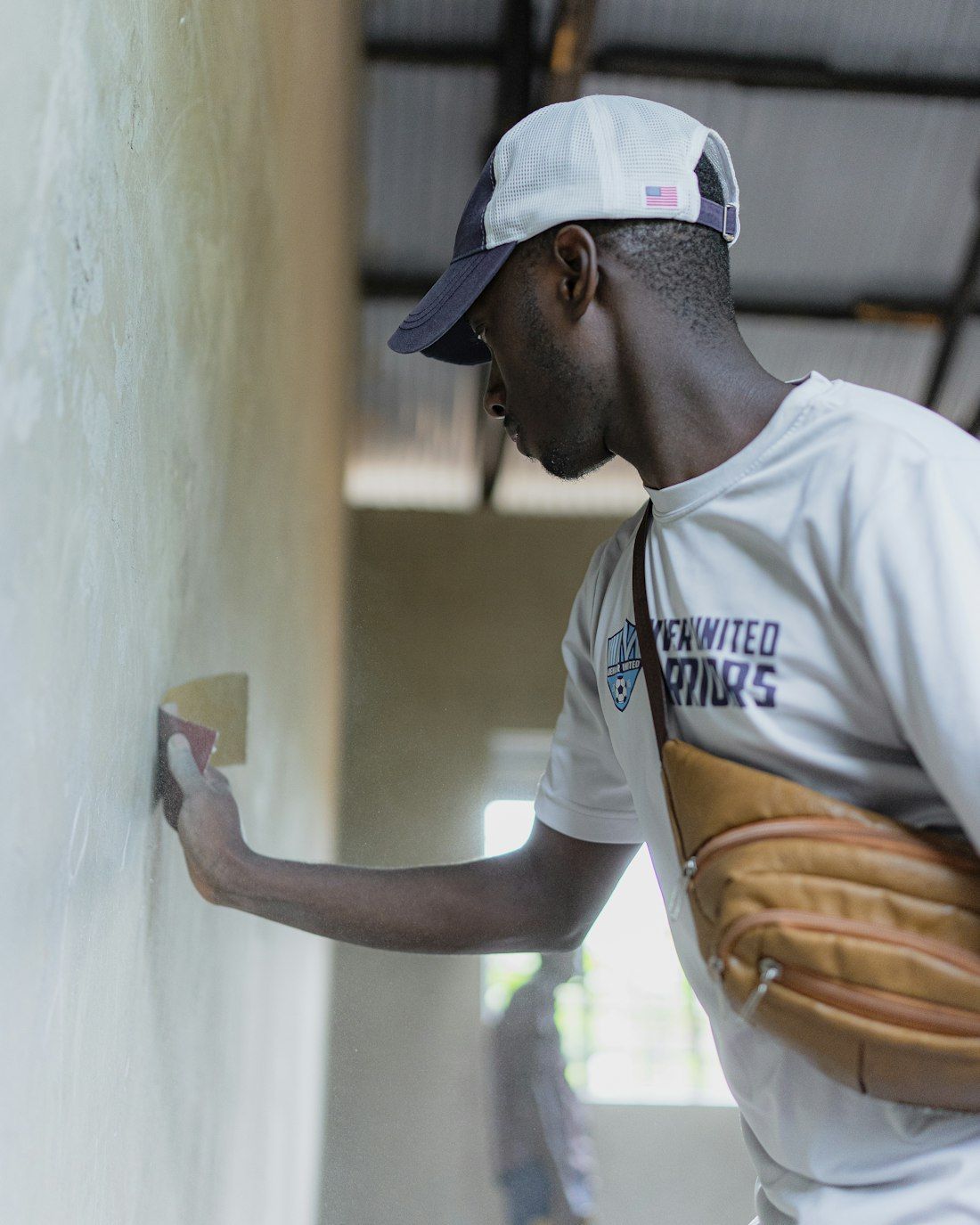 Artisan lissant un enduit de plâtre au mur (photo d’illustration)